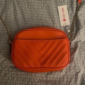 Lola Mae quilted crossbody bag in orange with a gold-colored chain strap. NWT
